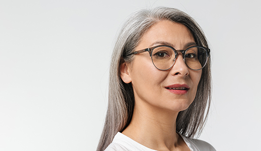 A person with long gray hair wearing a white shirt